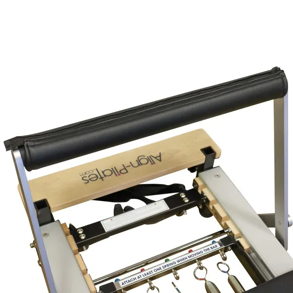 Align-Pilates Footbar Cover on a reformer footbar with cushioned PVC leather surface.